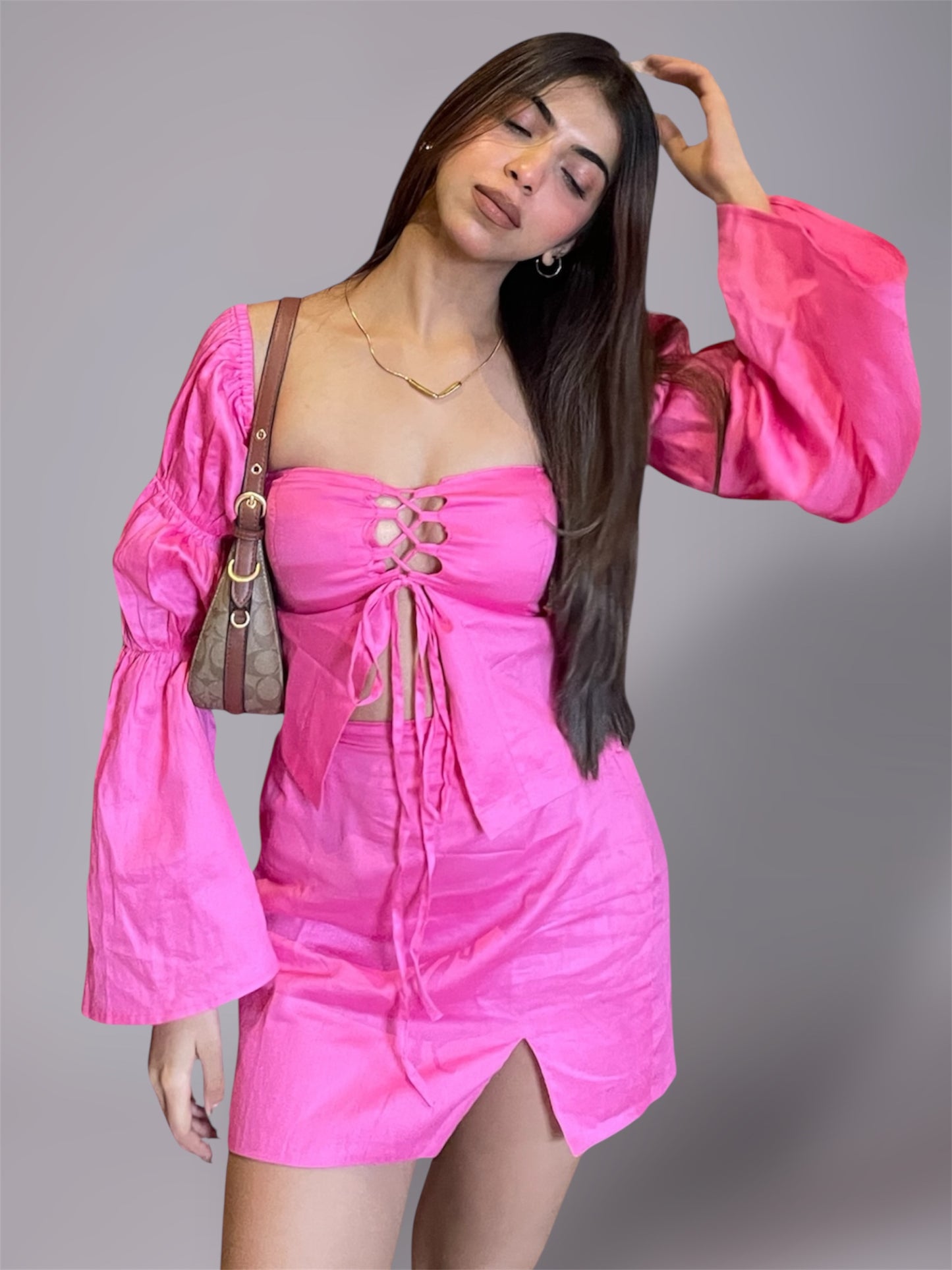 Woman wearing long puff sleeve pink top and mini slit skirt