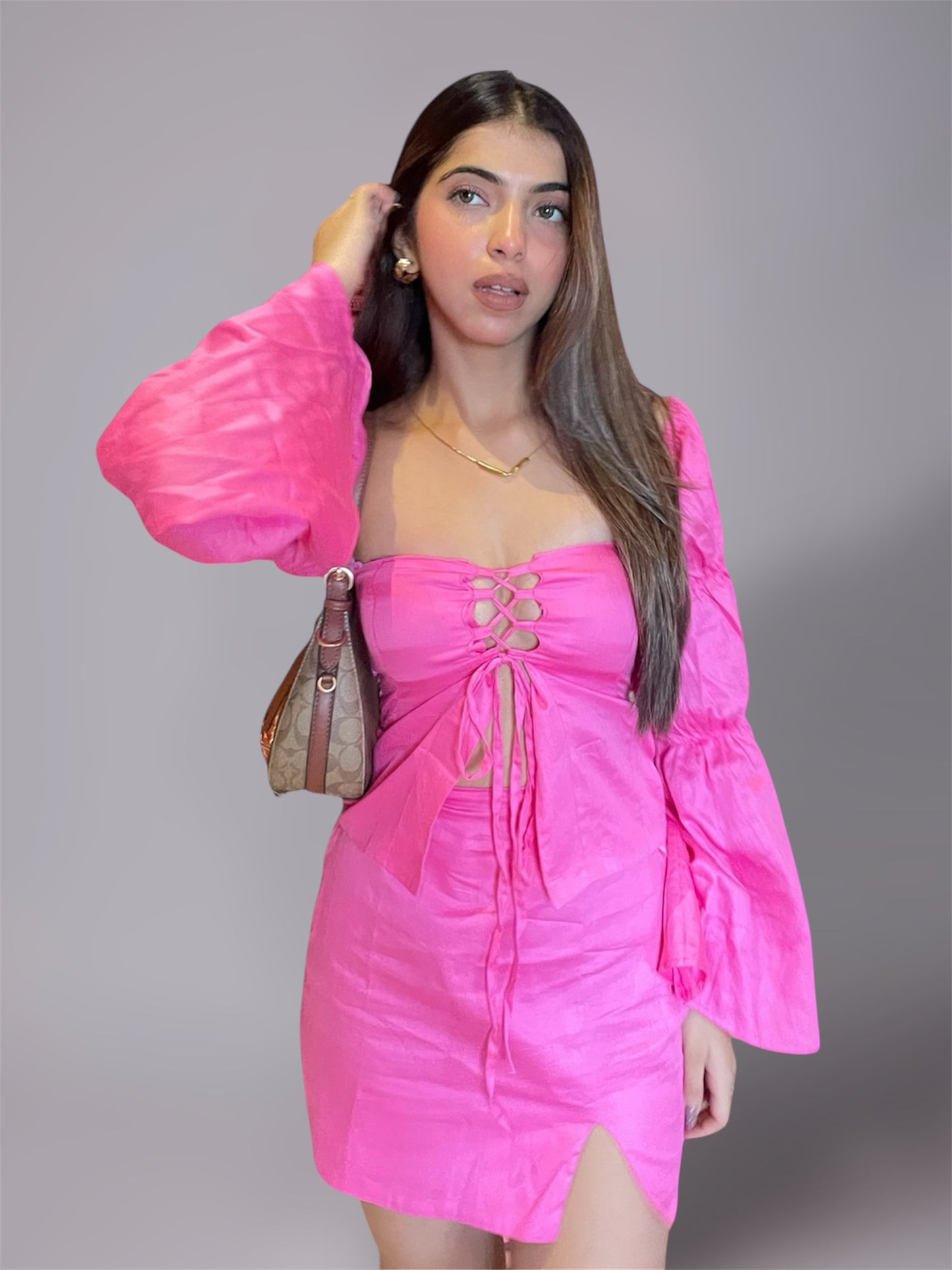Woman wearing long puff sleeve pink top and mini slit skirt