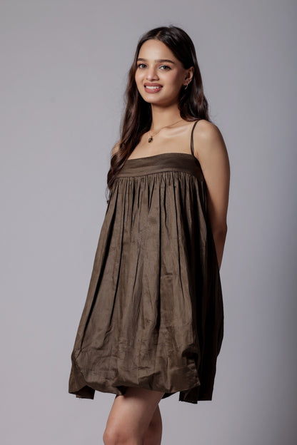 A model wearing a mocha brown, puffier silhouette dress with adjustable straps and a flared design.