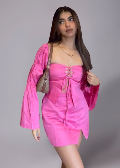 Woman wearing a puff sleeve pink top and mini slit skirt 