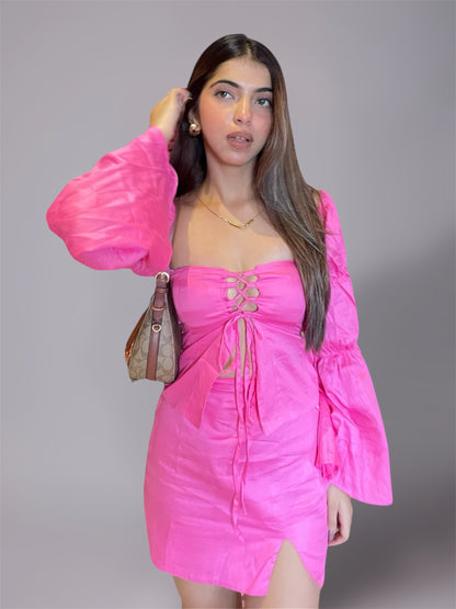 Woman wearing long puff sleeve pink top and mini slit skirt 