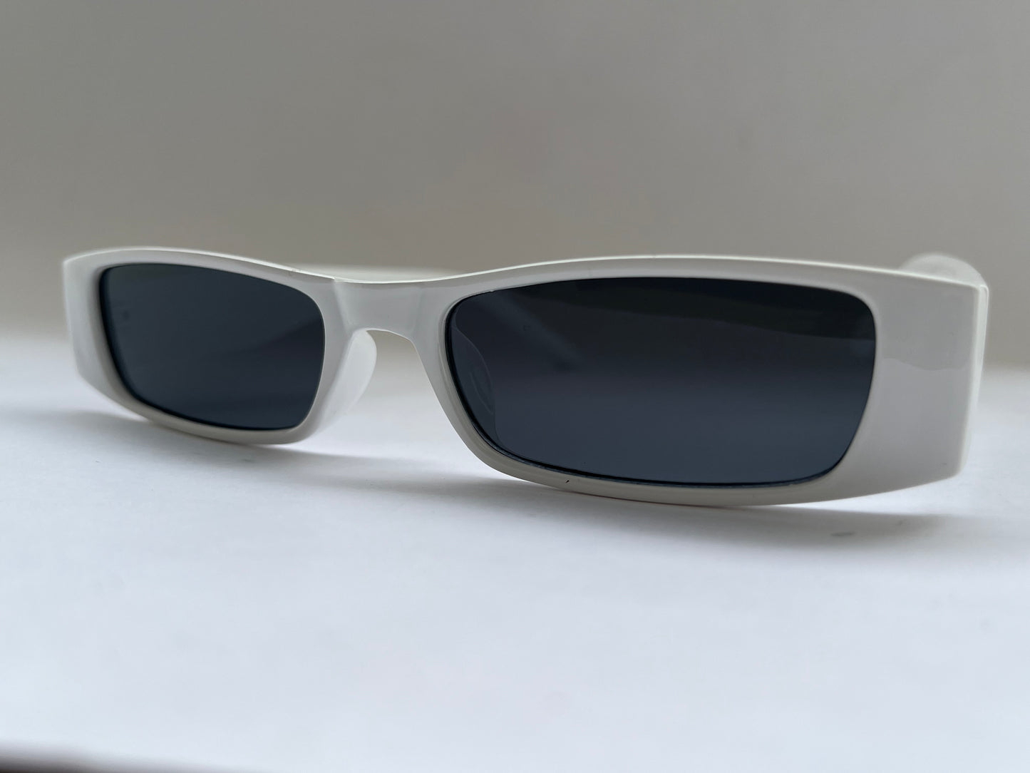 Sunglasses with dark lenses and white frame background