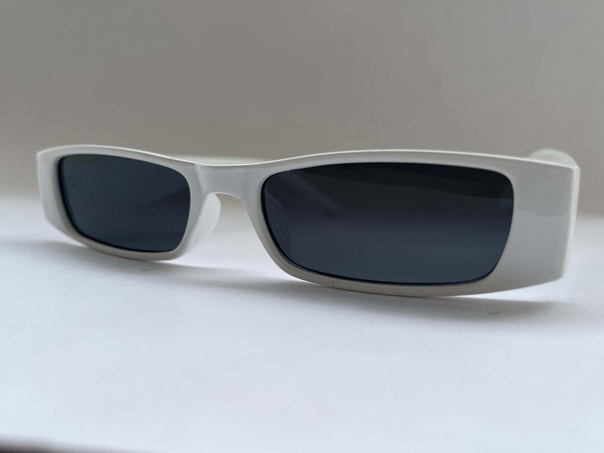 Sunglasses with dark lenses and white frame background