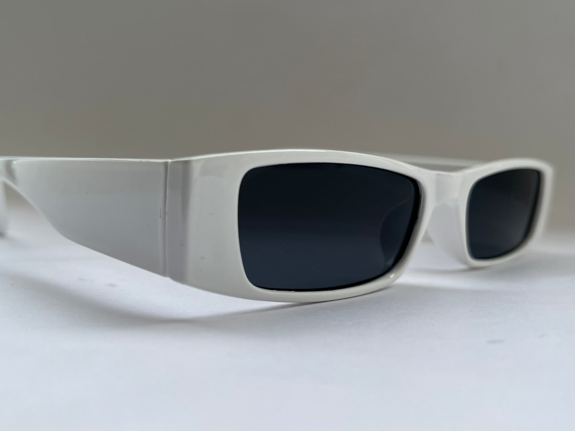 Sunglasses with dark lenses and white frame background