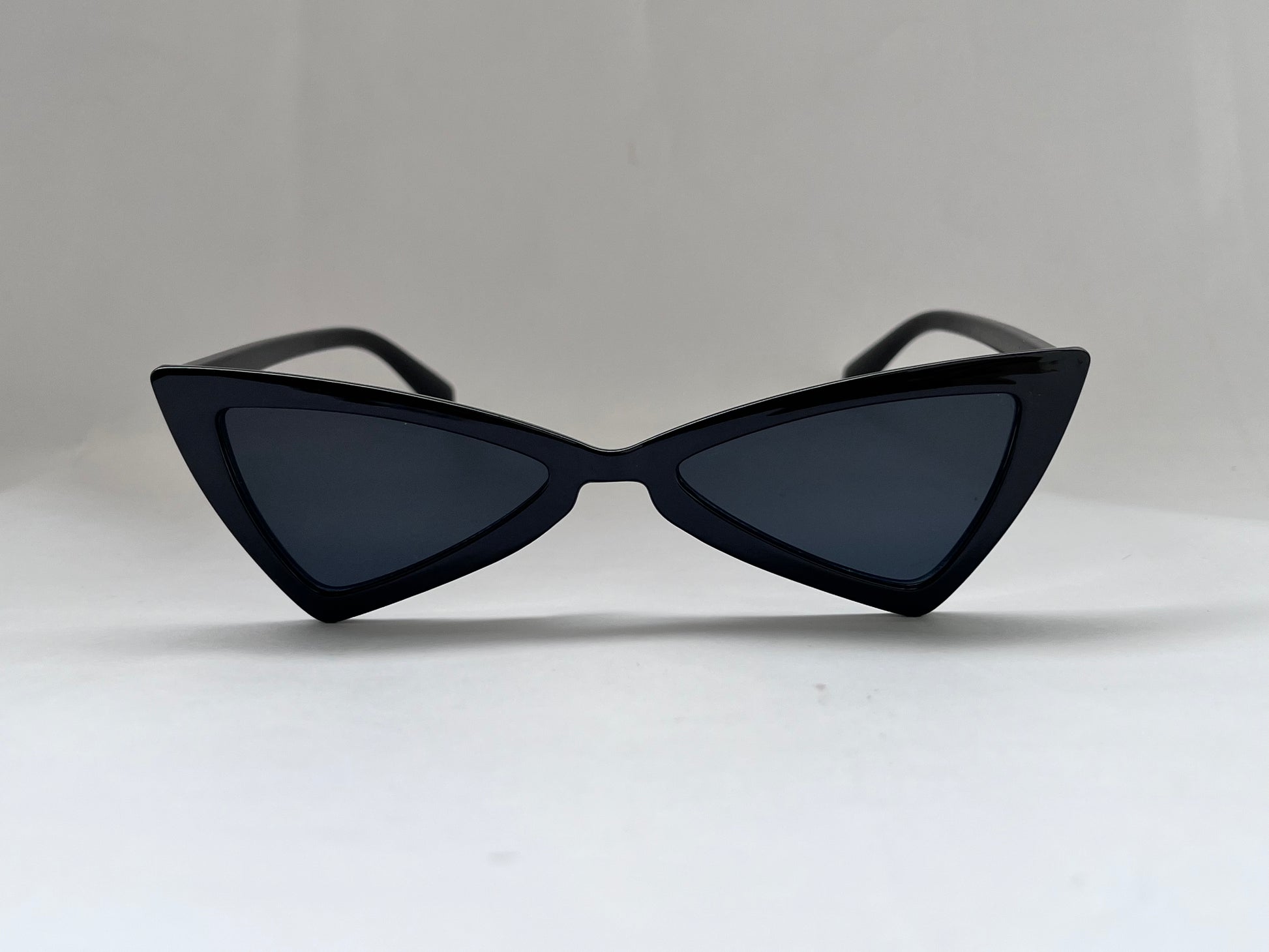 Black cat-eye sunglasses on a light gray background